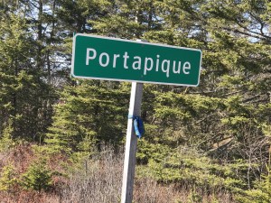 the green roadsign to Portapique with a tartan sash tied around the post