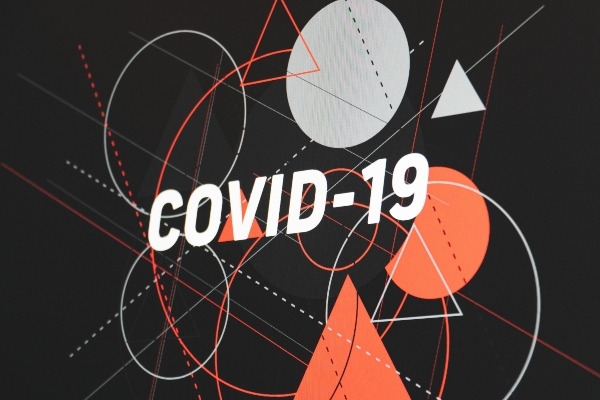 An illustration in mid-century modern style, with white capital letters spelling COVID 19 over a black background and orange and grey shapes and lines.
