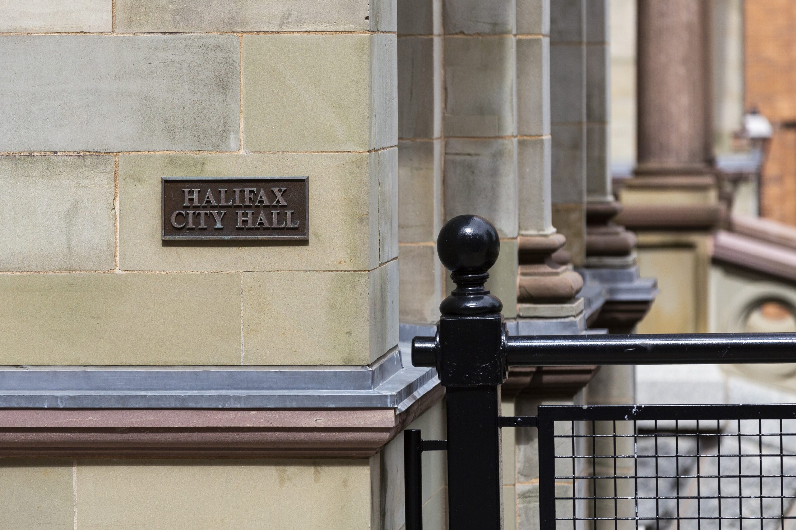 A photo of the bronze sign reading Halifax City Hall, set into the stone wall on the corner of the building. Taken in June 2021