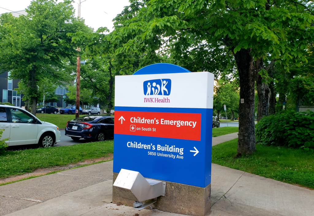 A sign outside the IWK Health Centre shows the direction of the children's emergency department and the children's building.