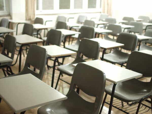 A photo of an empty school classroom with just desks and chairs..