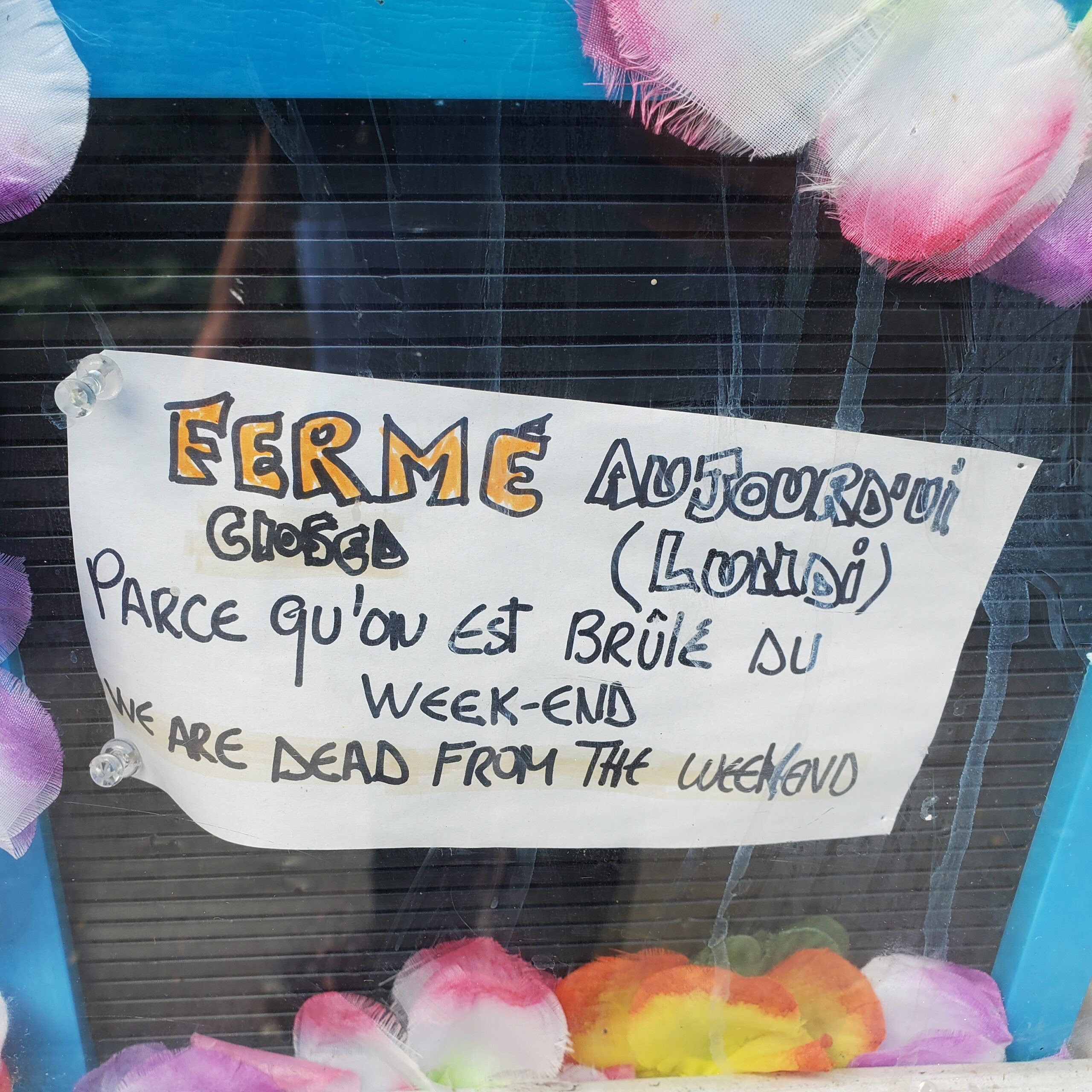 Sign in a window that says Closed today (Monday) because we are dead from the weekend, in English and French