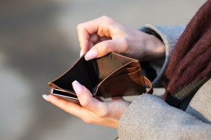 A closeup of an empty wallet being opened by a woman's hands