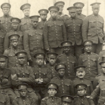 A sepia photo of a battalion of Black men in military uniforms