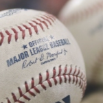 A baseball with red stitching and a Major Leagues Baseball logo