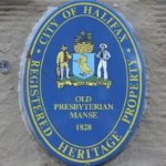 A blue oval heritage plaque on a building